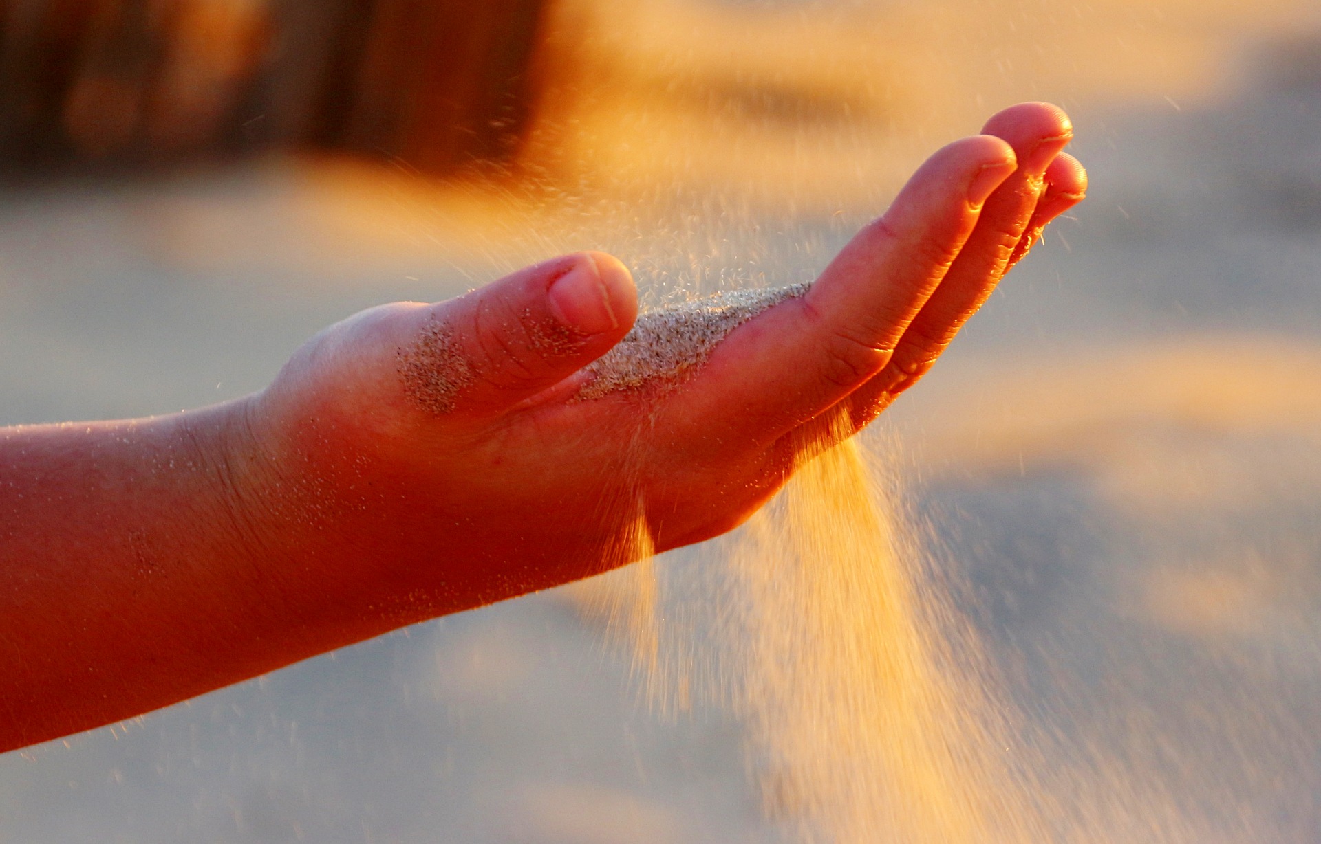 Sand slipping through fingers